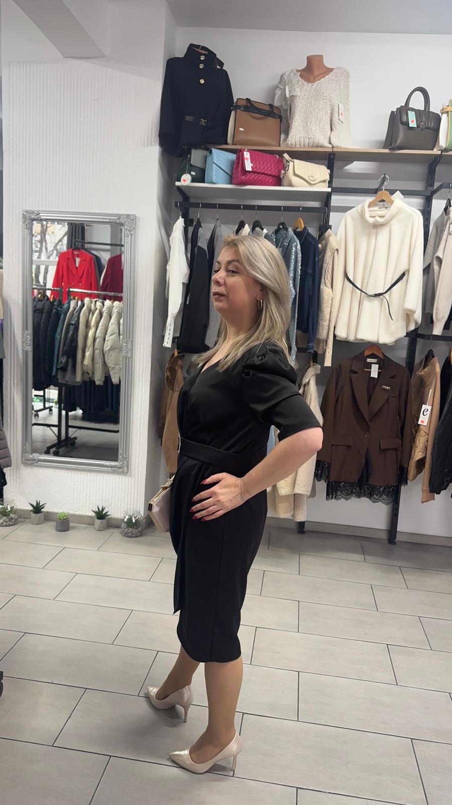 Rochie neagră cu decolteu petrecut și accesoriu decorativ în talie